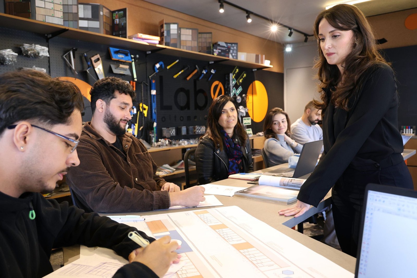 Alunos do Lab86 reunidos à mesa em atividade de criação de projetos de arquitetura